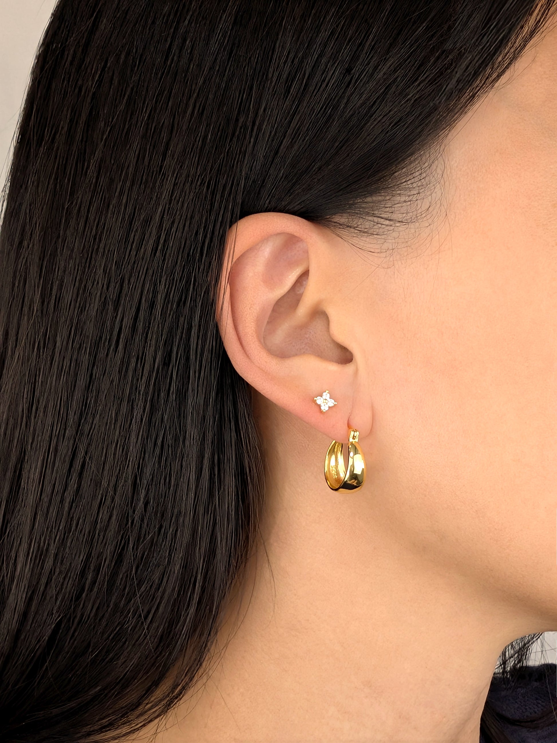 FAVES Britt 18K gold over sterling silver oval hoop earring worn on ear with diamond stud.