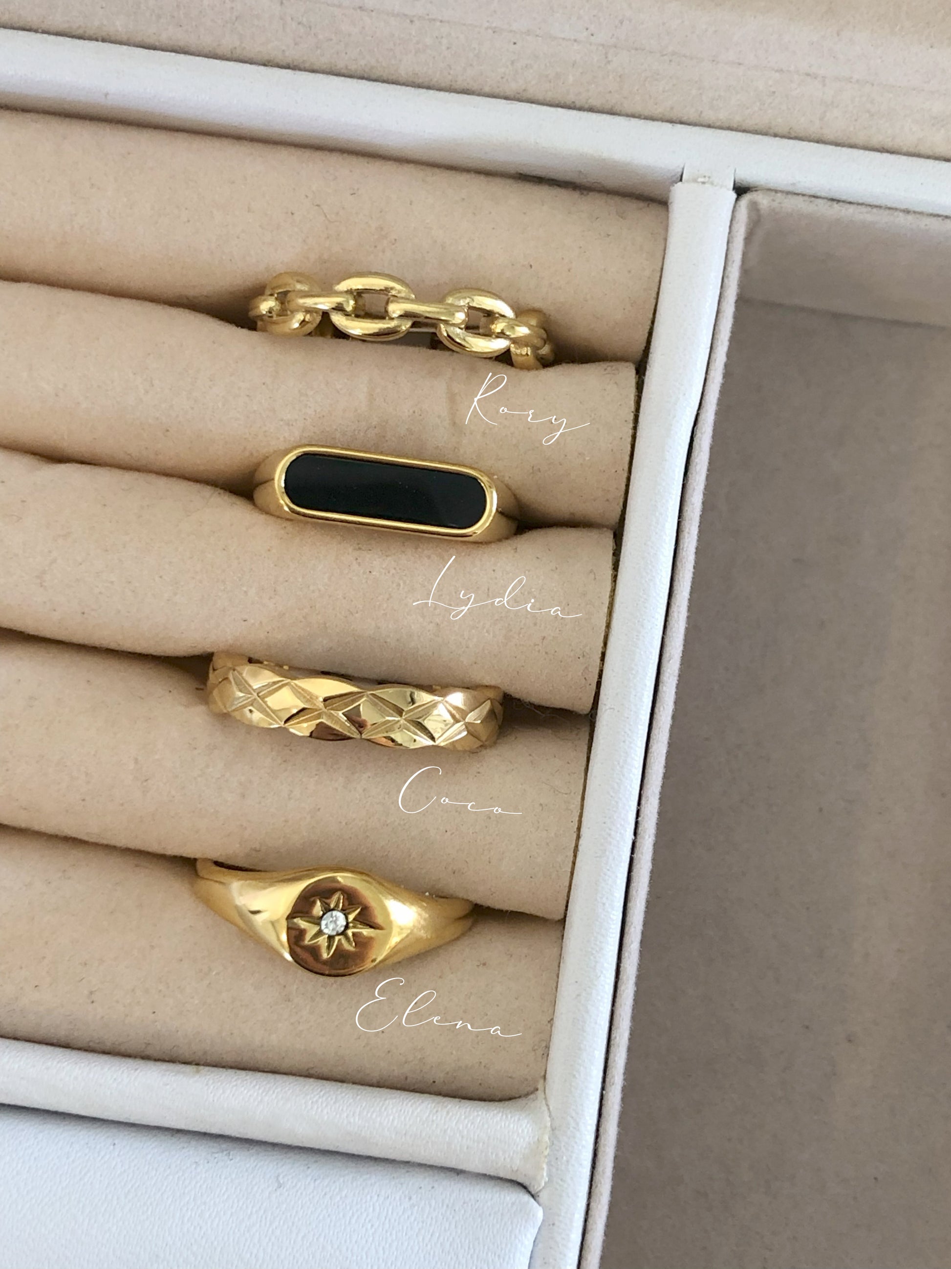 FAVES Lydia Black Onyx ring stacked in a jewelry box with other gold rings